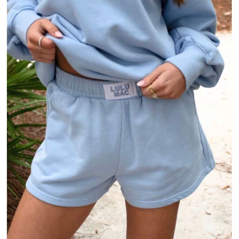 Light blue sweatshirt and shorts with 'LULU MAC' label, worn by a person outdoors.