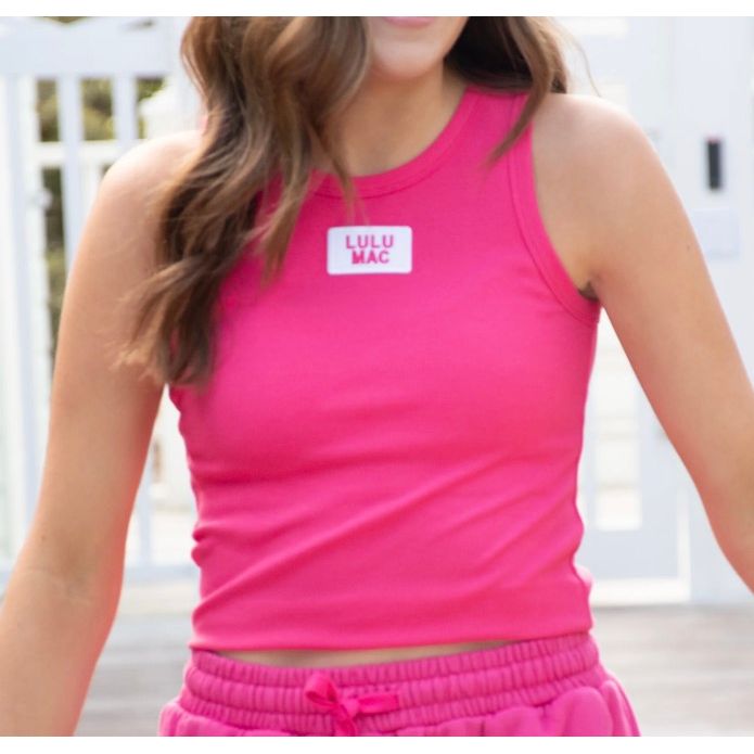 Person wearing a pink 'LULU MAC' tank top and shorts.