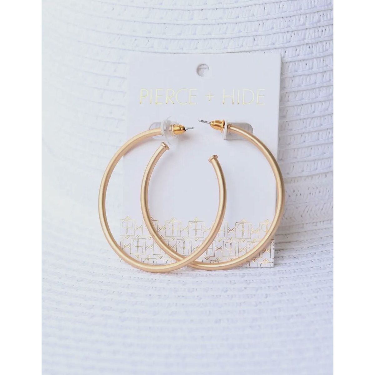 Gold hoop earrings on a white card with 'Pierce & Hall' branding against a light gray background.