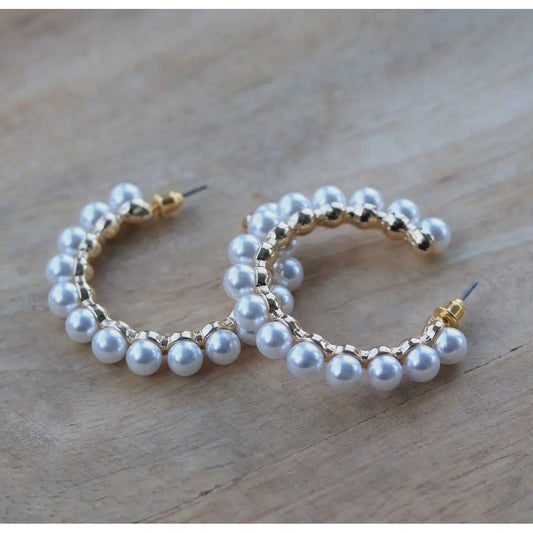 Pearl hoop earrings on a wooden surface