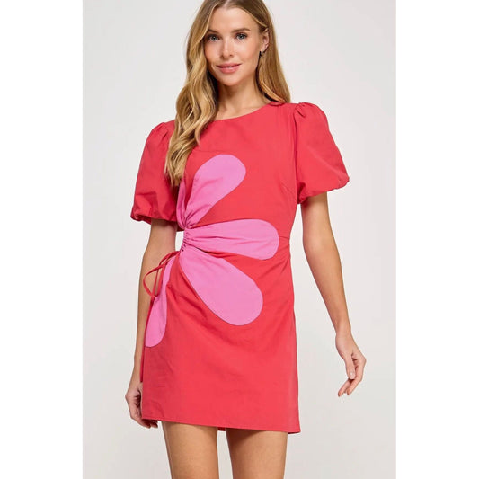 Woman wearing a red dress with a pink flower design on a white background