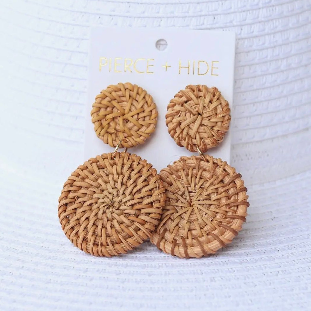 Pair of woven rattan earrings on a 'Pierce + Hide' branded card against a white background.