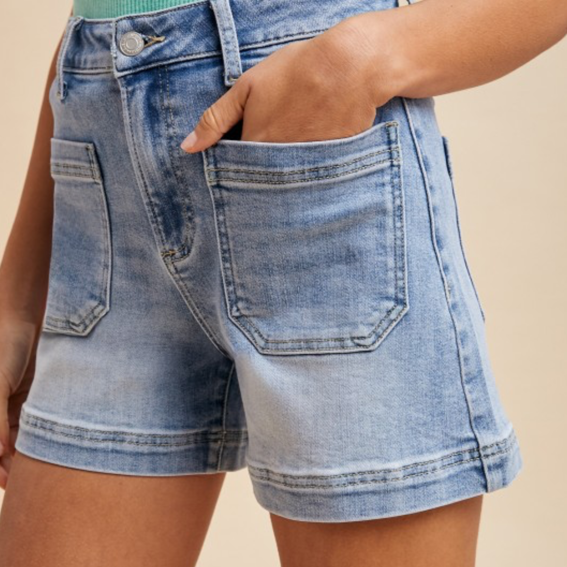 Denim shorts worn by a person on a beige background
