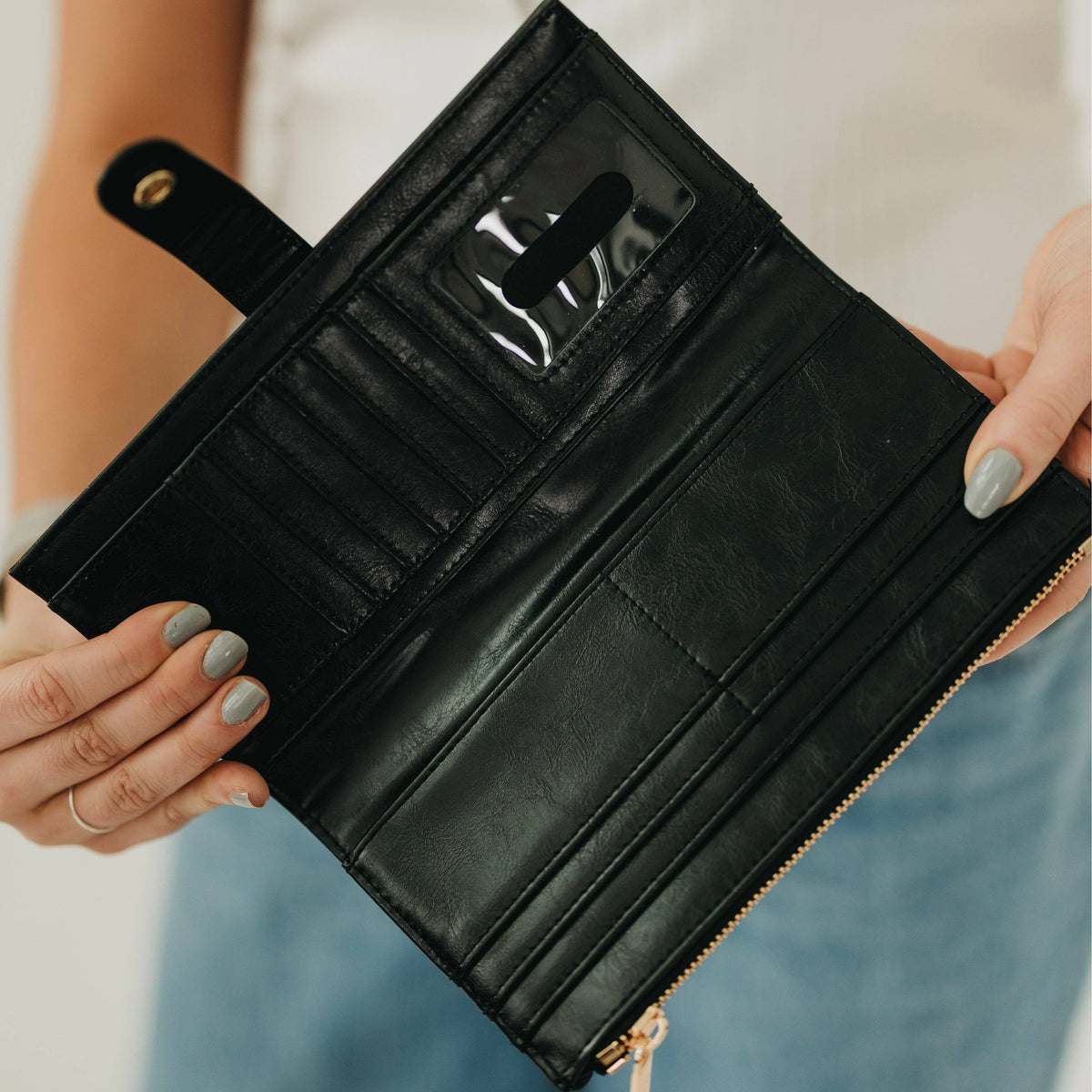 Annie Ks Boutique black Essentials Carryall Wallet open to show interior card slots, cash pockets, and ID window.