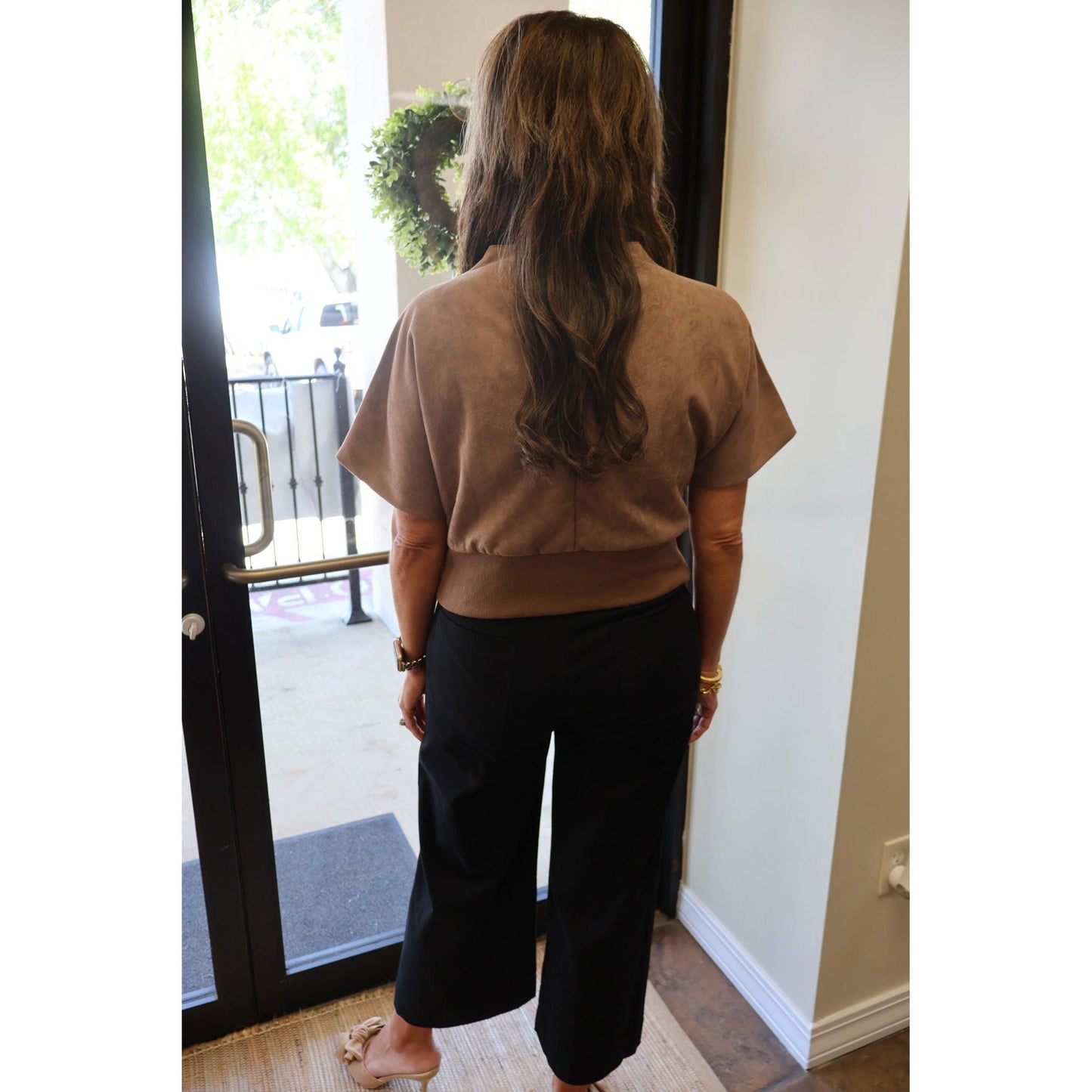 Annie Ks Boutique black cropped wide-leg pants paired with a brown short-sleeve top, viewed from behind.