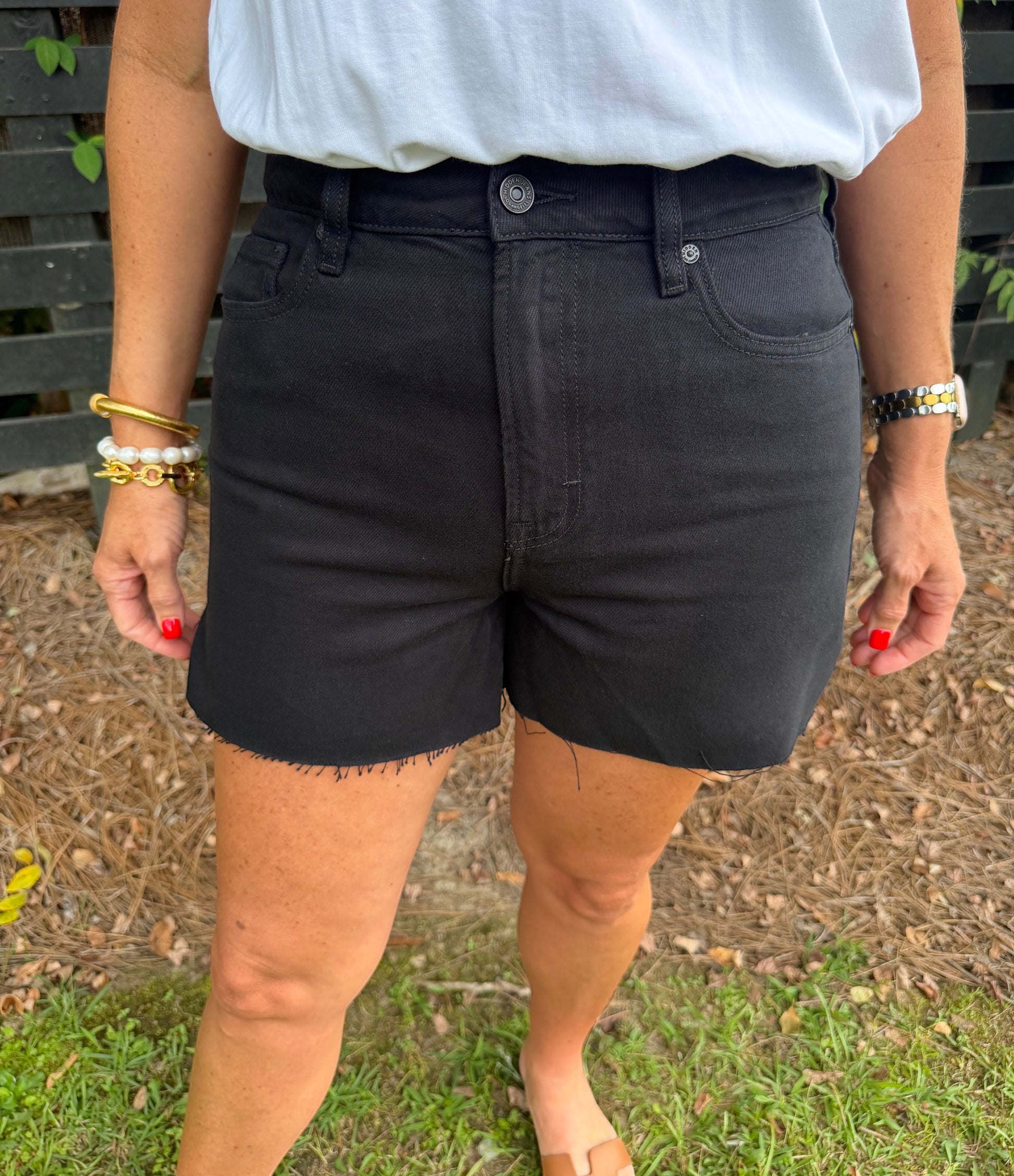 Annie Ks Boutique high-waisted black denim shorts with a raw hem, worn with a white t-shirt for a casual look.