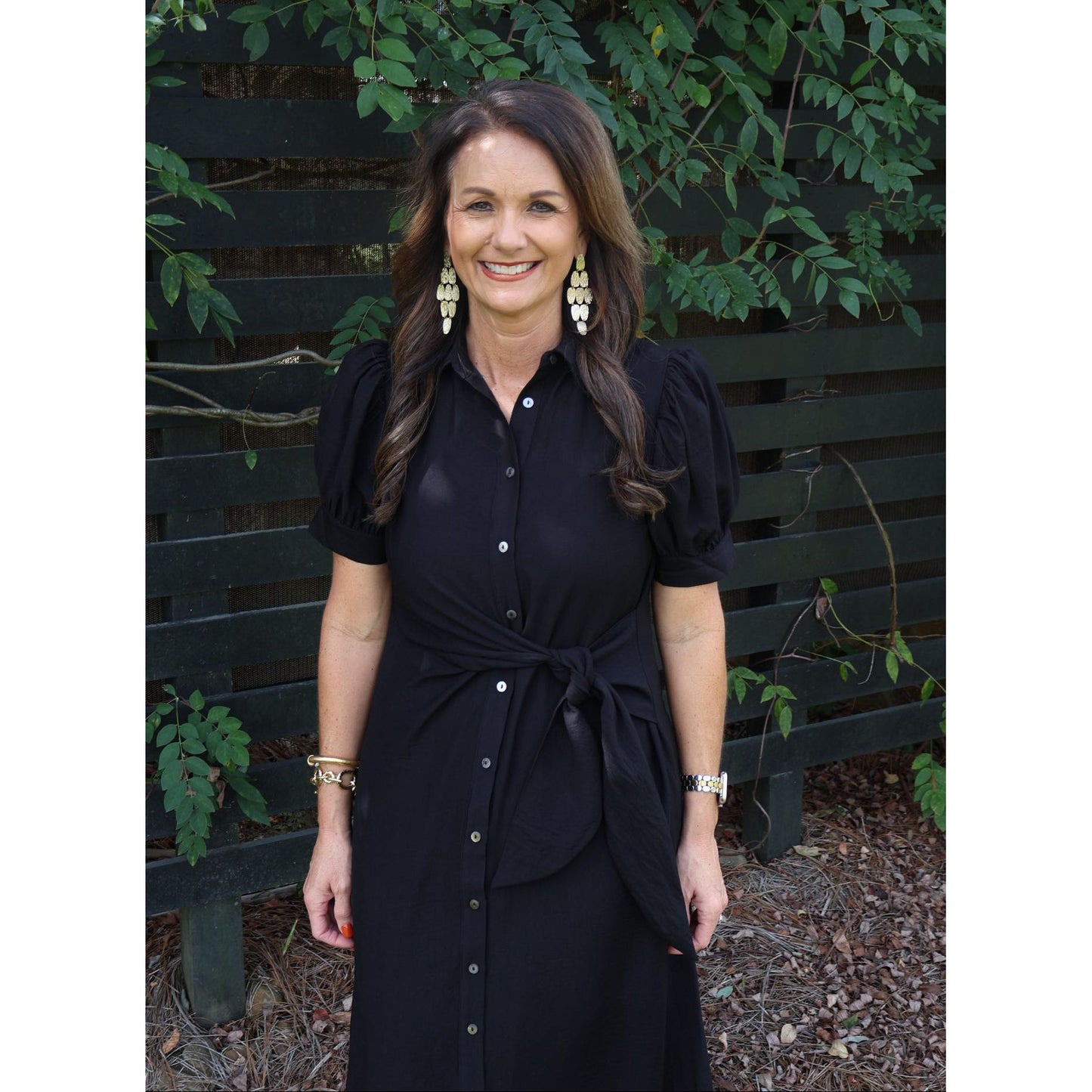 Annie Ks Boutique black midi shirt dress with puff sleeves, button front, and self-tie belt worn by a smiling woman.