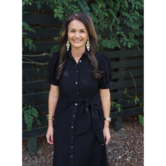 Annie Ks Boutique black midi shirt dress with puff sleeves, button front, and self-tie belt worn by a smiling woman.
