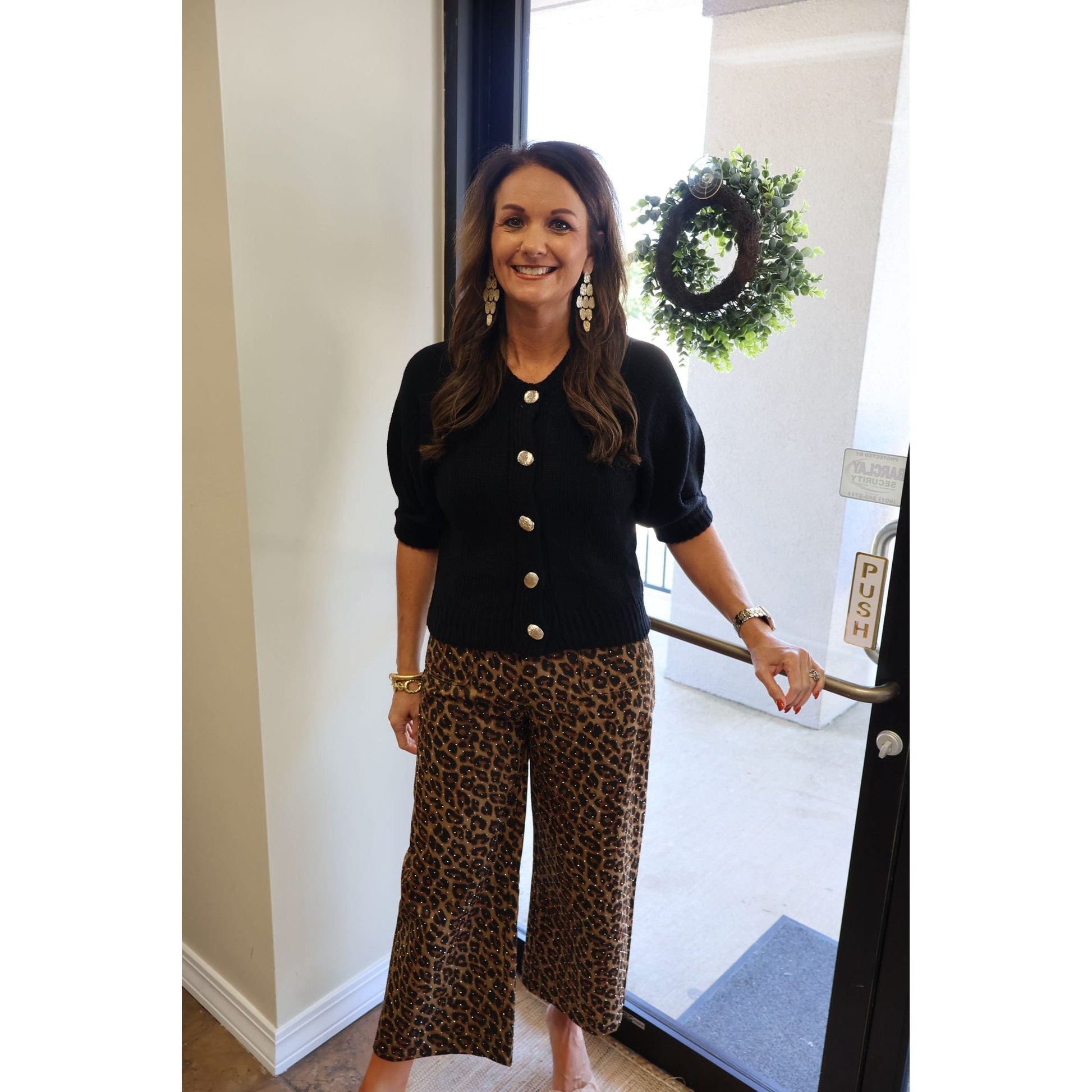 Annie Ks Boutique black knit cardigan with puff sleeves and gold buttons worn with leopard print cropped trousers