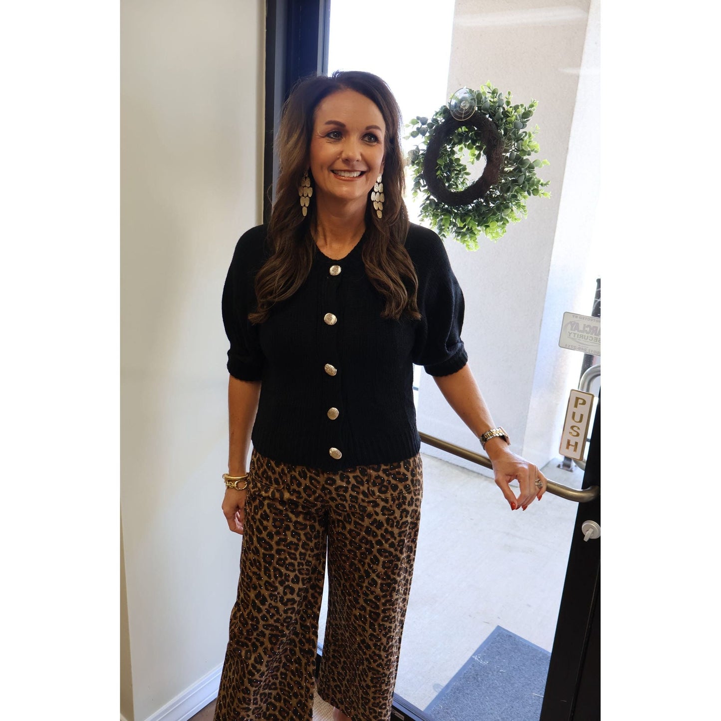 Annie Ks Boutique black knit cardigan with puff sleeves and gold buttons worn with leopard print trousers
