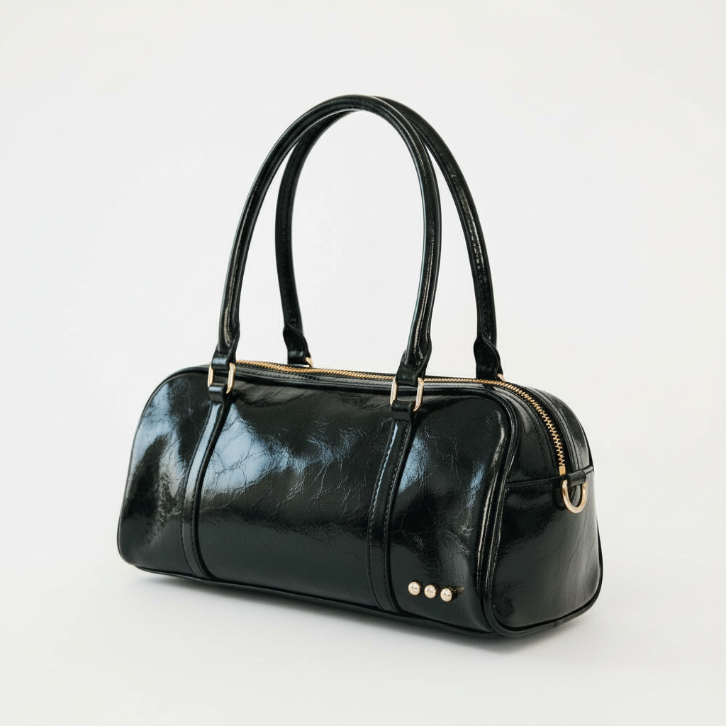 Annie Ks Boutique Arlys barrel shoulder bag in smooth black vegan leather with top handles and gold hardware details.