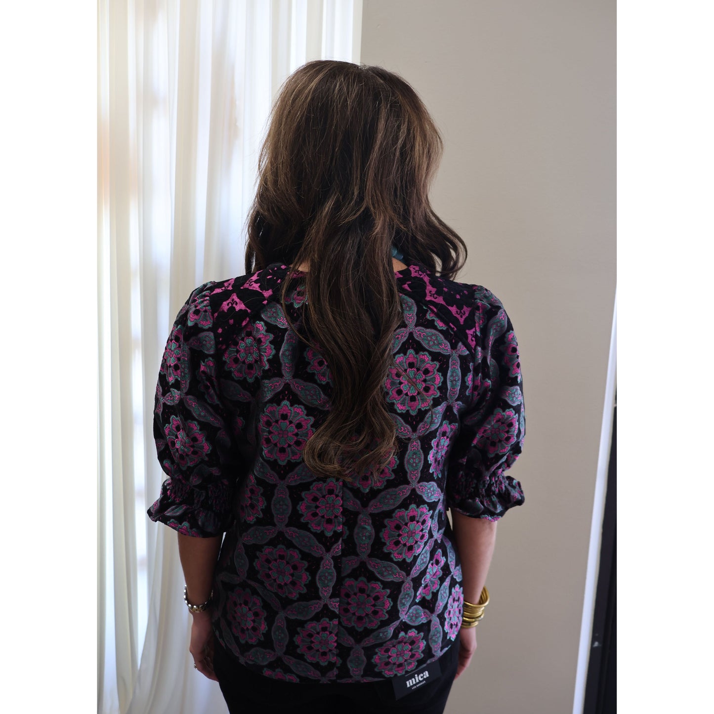 Annie Ks Boutique black velvet jacquard top with purple geometric medallion print, puff sleeves, and smocked cuffs.