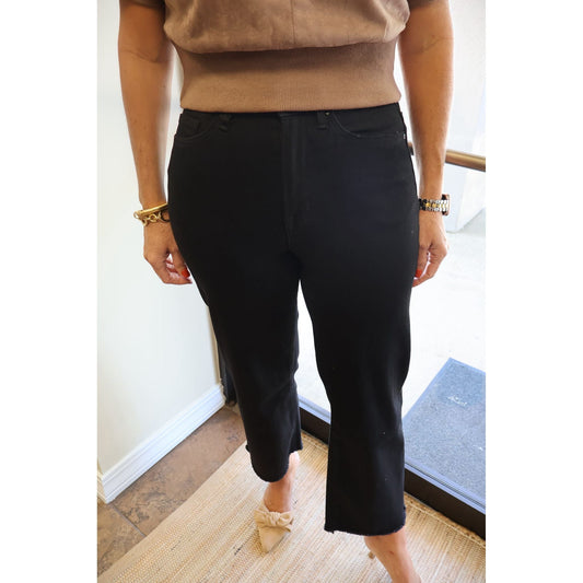 Annie Ks Boutique black high-rise wide-leg cropped denim jeans with a raw hem worn with a beige top and heels