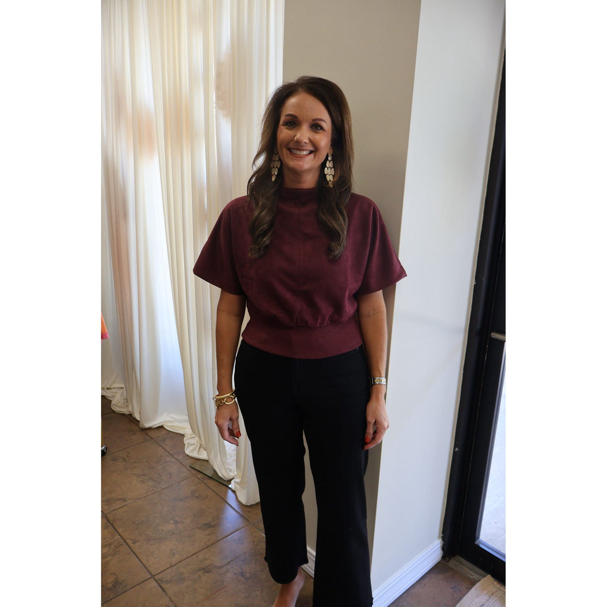 Annie Ks Boutique model wearing high-rise black wide-leg cropped jeans paired with a burgundy short-sleeve top