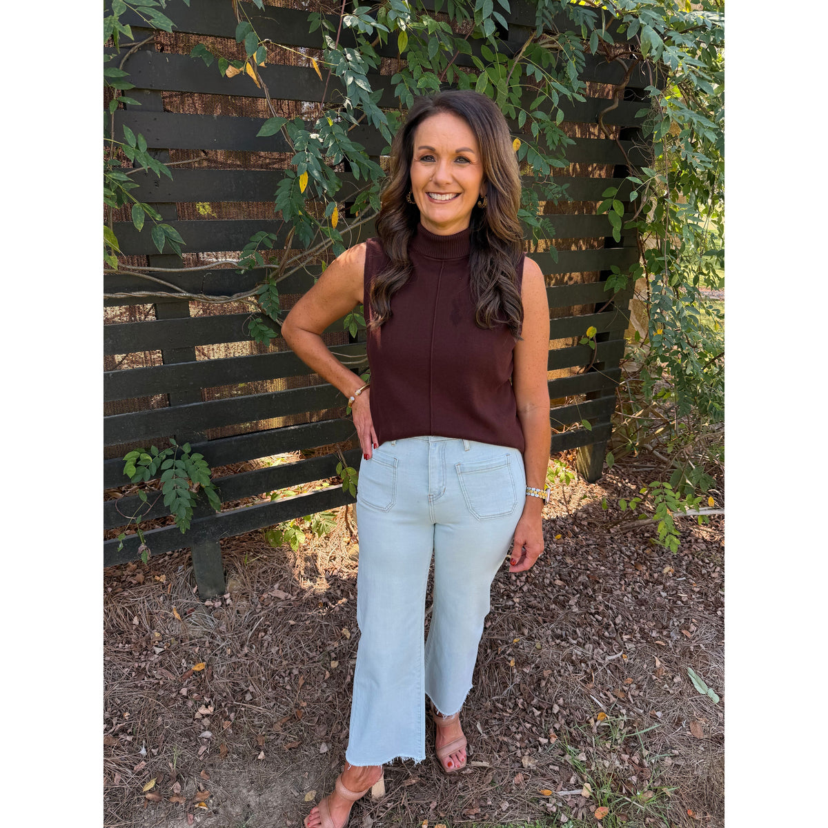 Annie Ks Boutique model wearing high-rise wide leg cropped jeans in Blizzard Blue with a raw hem and brown sleeveless top