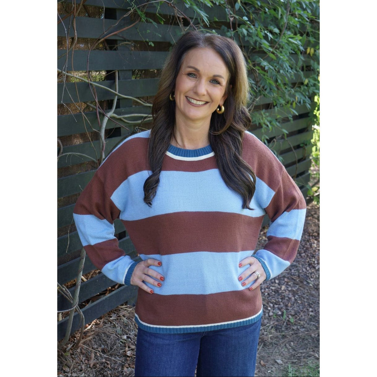 Annie Ks Boutique model wearing a blue and brown wide stripe crew neck sweater with ribbed trim and relaxed fit