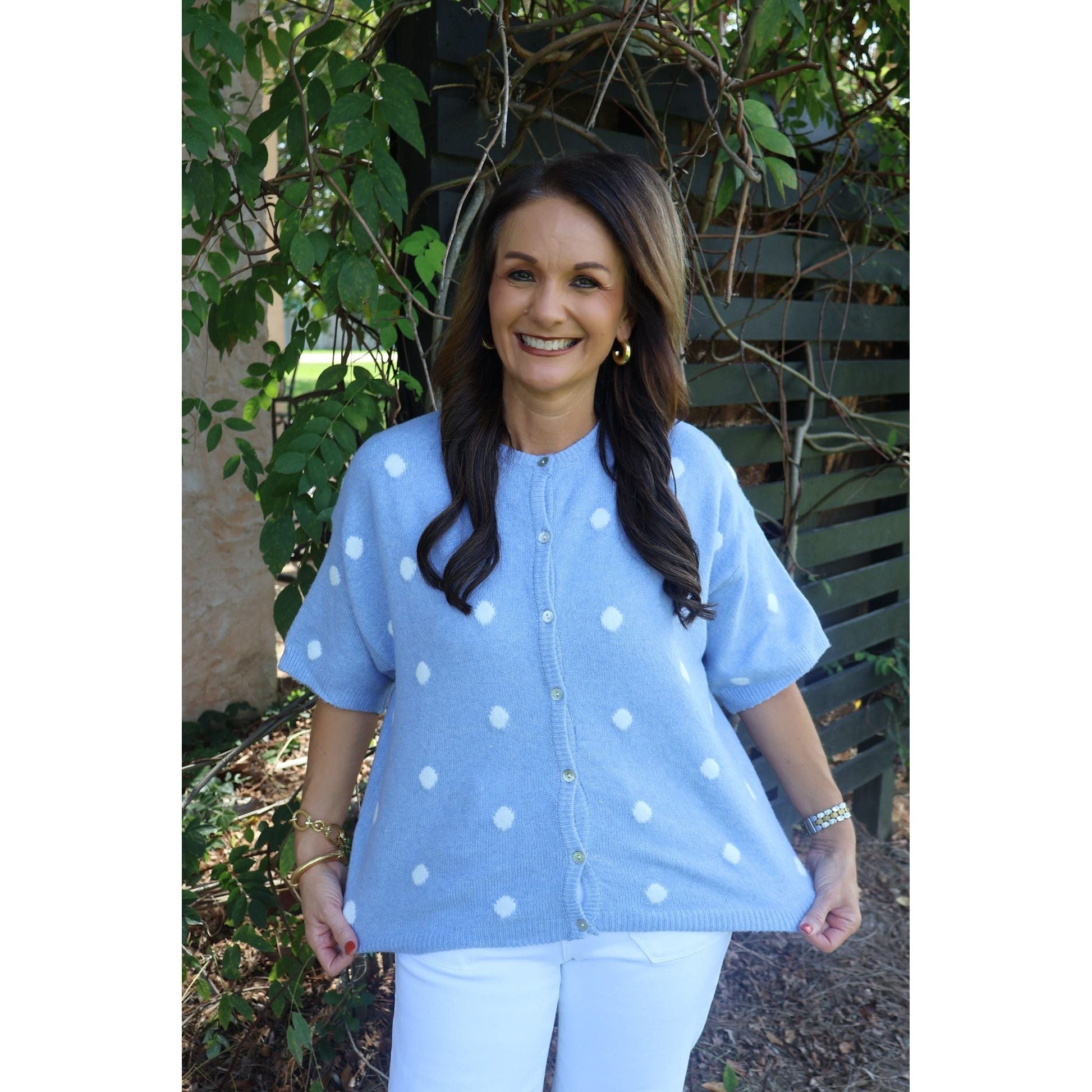 Annie Ks Boutique sky blue short-sleeve knit cardigan with white polka dots worn by a smiling woman