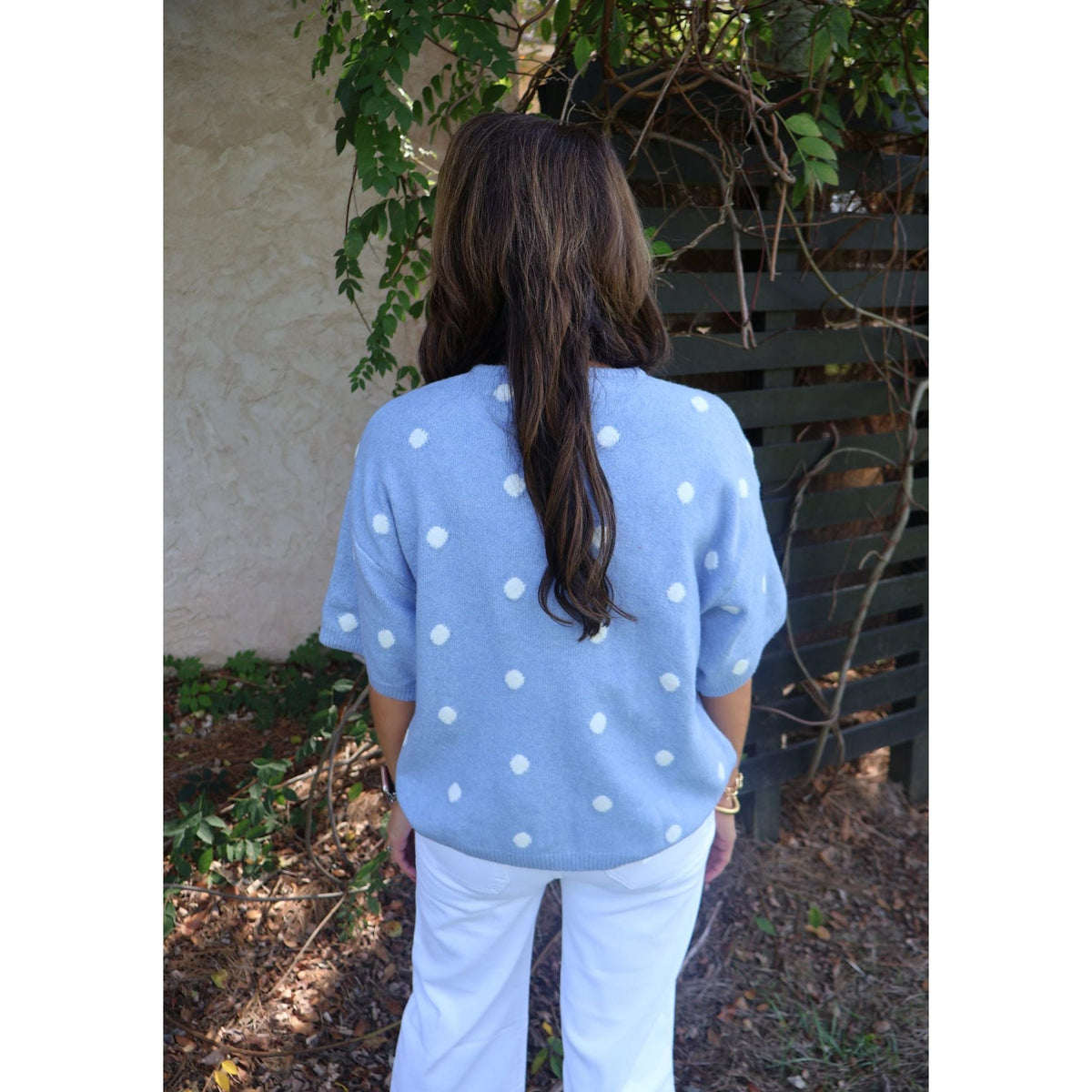 Annie Ks Boutique sky blue short-sleeve knit cardigan with white polka dots worn by a woman, back view