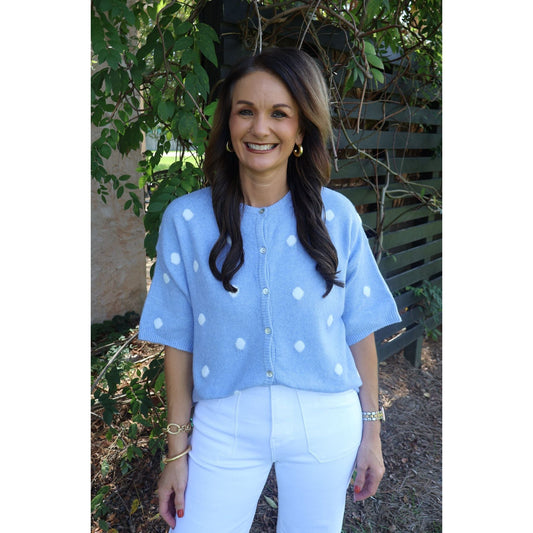 Annie Ks Boutique sky blue short-sleeve knit cardigan with white polka dots and button-front, worn by a smiling woman.