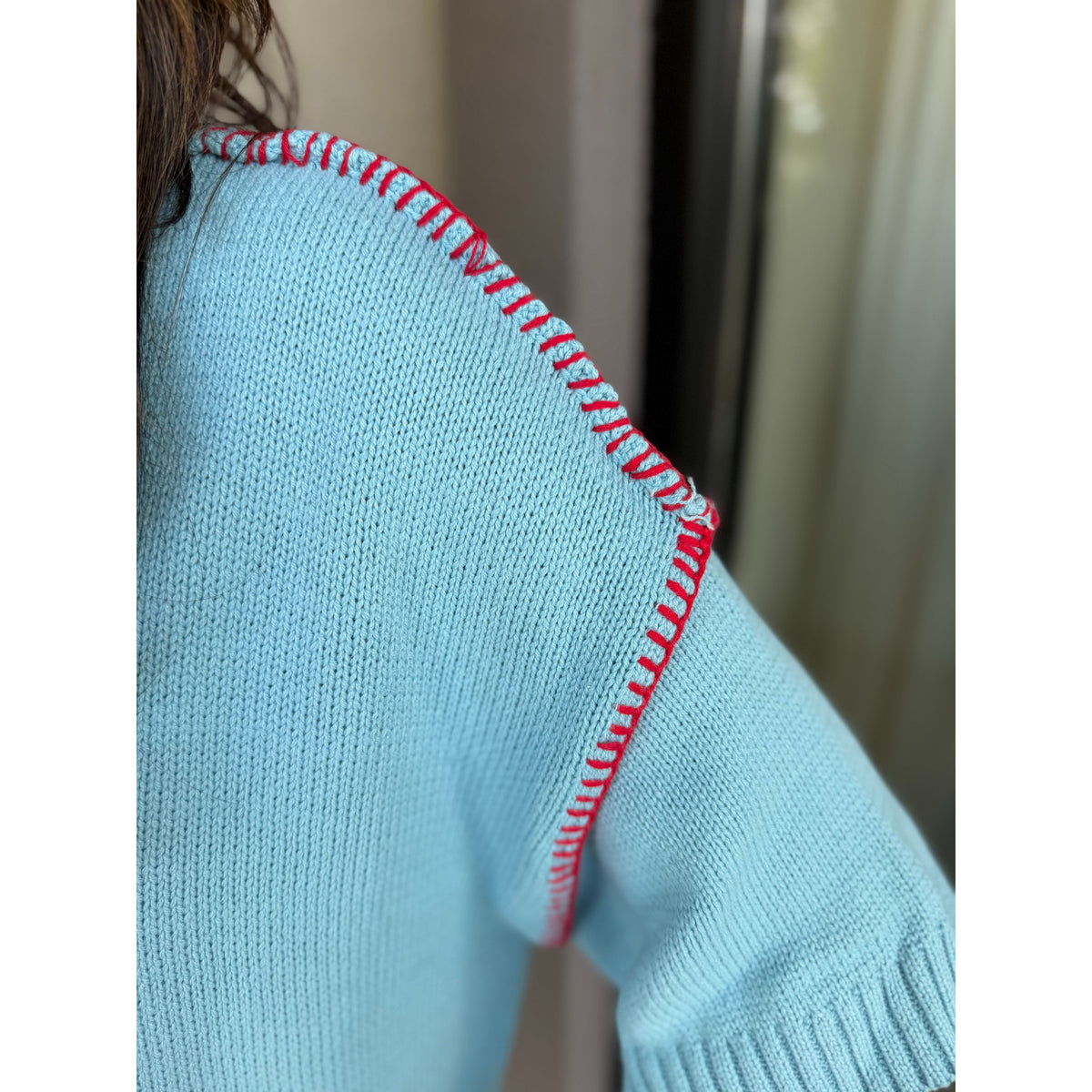 Annie Ks Boutique sky blue short sleeve sweater featuring contrast red blanket stitching along the shoulder seam