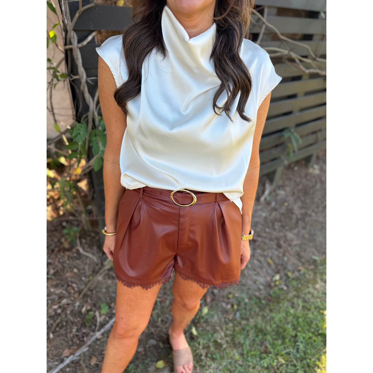 Annie Ks Boutique brick faux leather pleated shorts featuring a delicate lace hem and a gold-tone belted waist.