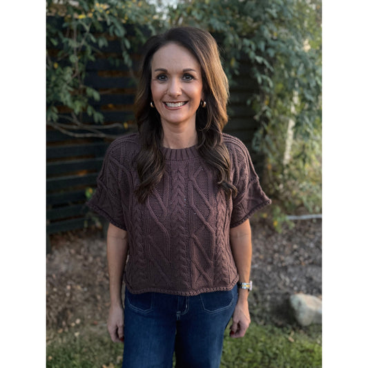 Annie Ks Boutique brown short sleeve cable knit sweater with a round neck and boxy cropped fit worn by a woman