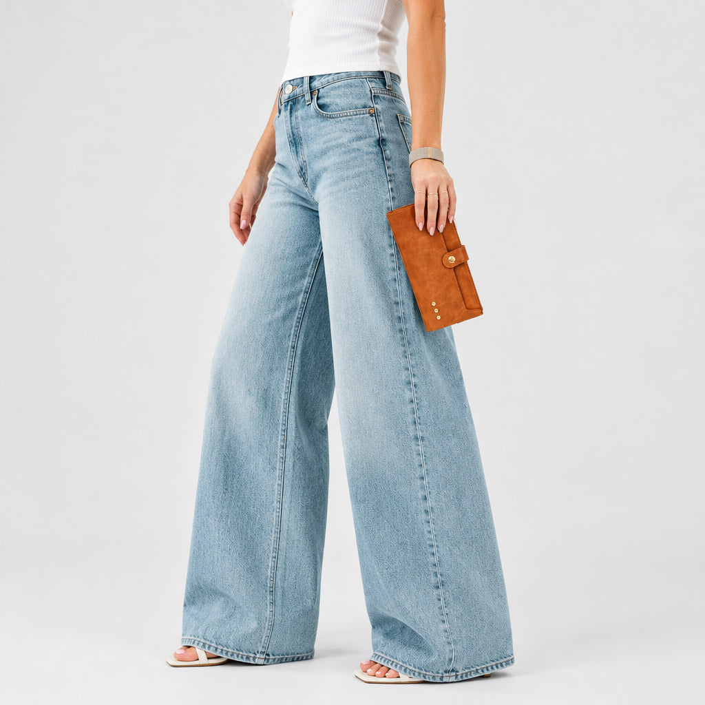 Annie Ks Boutique brown Essentials Carryall Wallet held as a clutch by a woman wearing jeans and a white top
