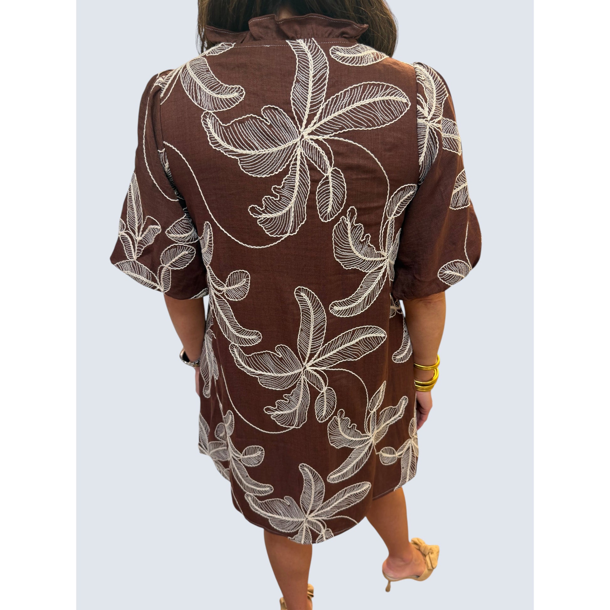 Back view of Annie Ks Boutique brown woven dress with white leaf embroidery, puff sleeves, and a relaxed shift fit.