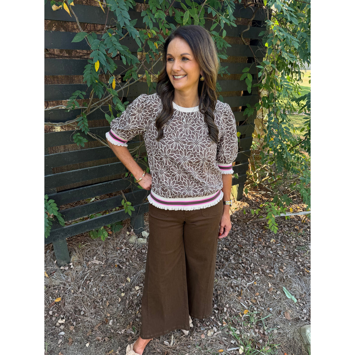Annie Ks Boutique brown floral eyelet top with puff sleeves and striped ribbed trim worn by a woman outdoors