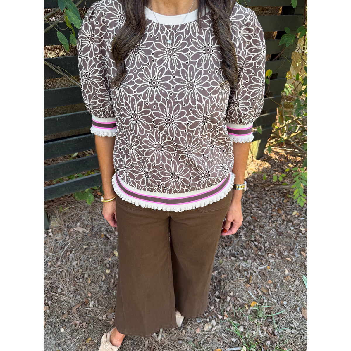 Annie Ks Boutique brown floral eyelet top with puff sleeves and striped ribbed trim worn with brown trousers