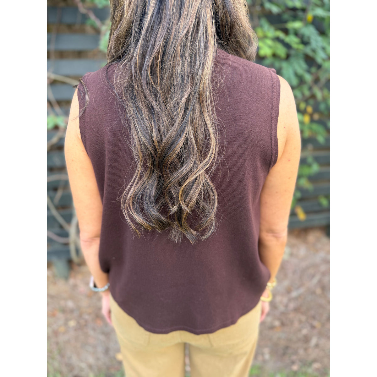 Annie Ks Boutique brown sleeveless cotton turtleneck top viewed from the back on a woman with long wavy hair