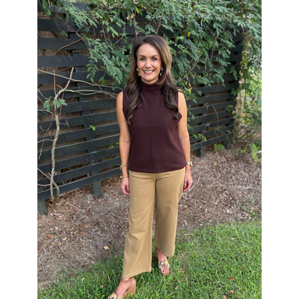 Annie Ks Boutique brown sleeveless cotton turtleneck with center-front seam worn by a woman with tan trousers