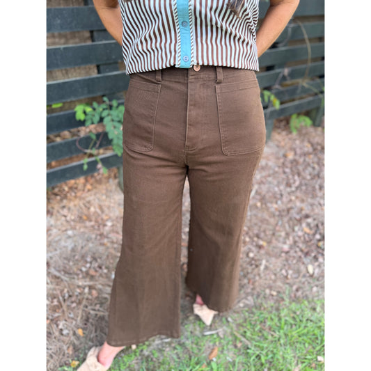 Annie Ks Boutique brown wide-leg pants with front patch pockets and a zip-fly closure, worn with a striped shirt.