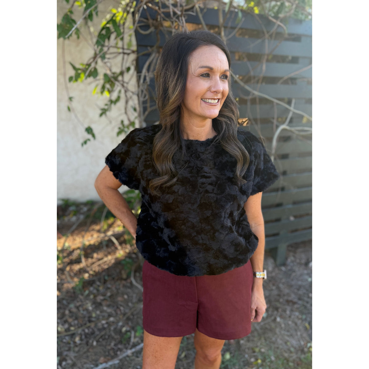 Annie Ks Boutique burgundy faux suede shorts with side pockets worn by a woman with a black textured top