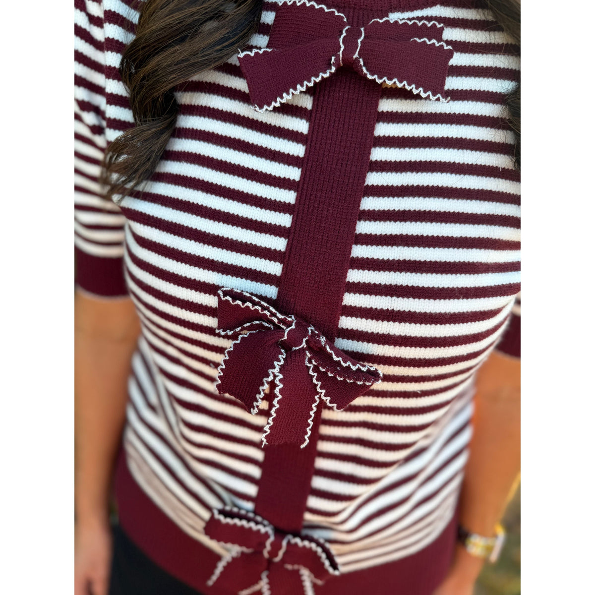 Annie Ks Boutique burgundy and white striped knit cardigan featuring decorative front bows and short sleeves.