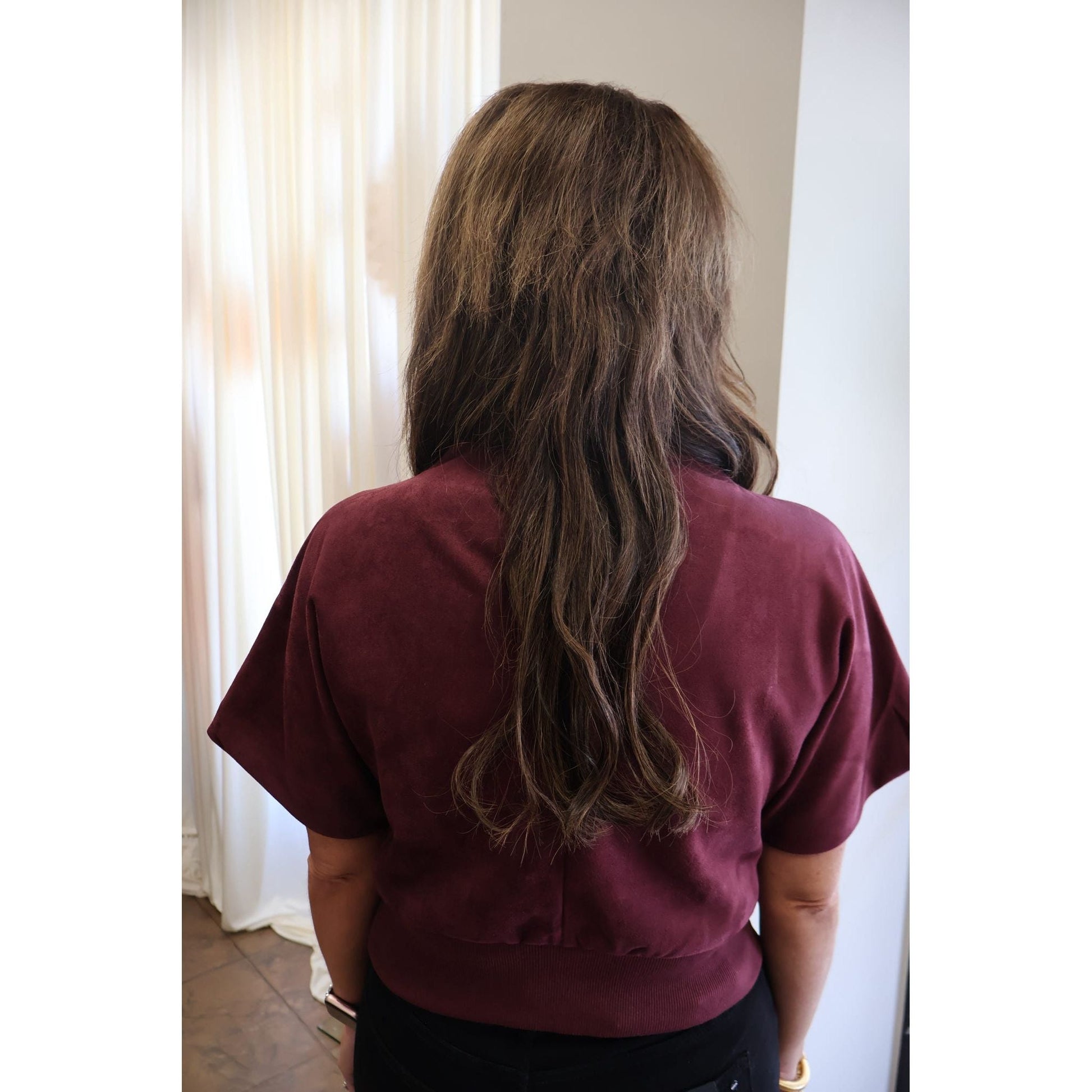 Back view of a woman wearing an Annie Ks Boutique burgundy suede-look mock neck top with short sleeves