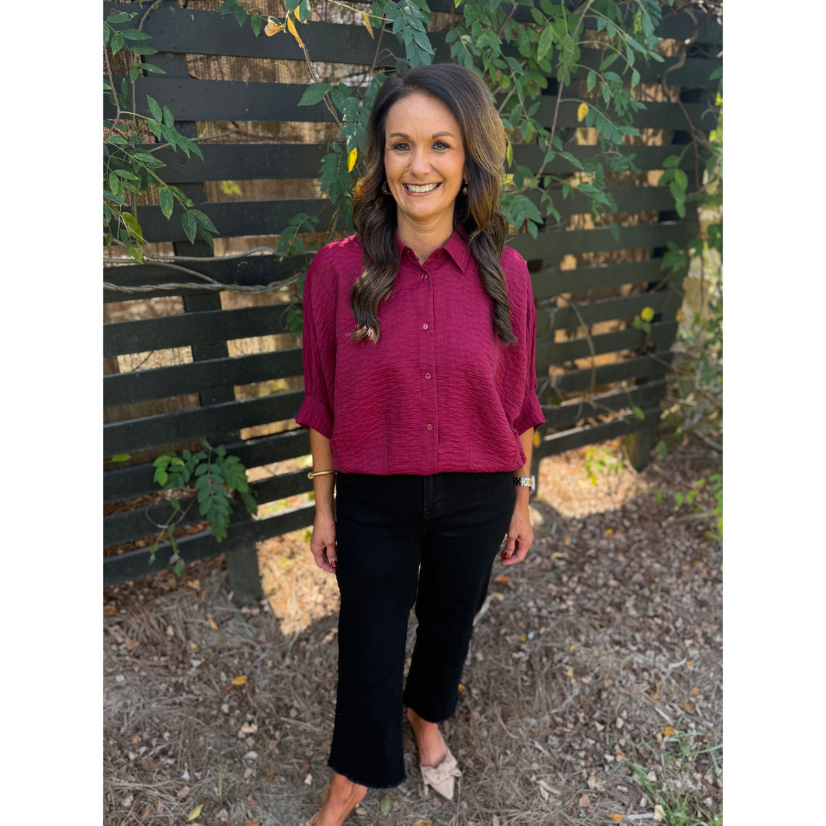Annie Ks Boutique burgundy textured short sleeve blouse with a collar and button-front, worn with black trousers.
