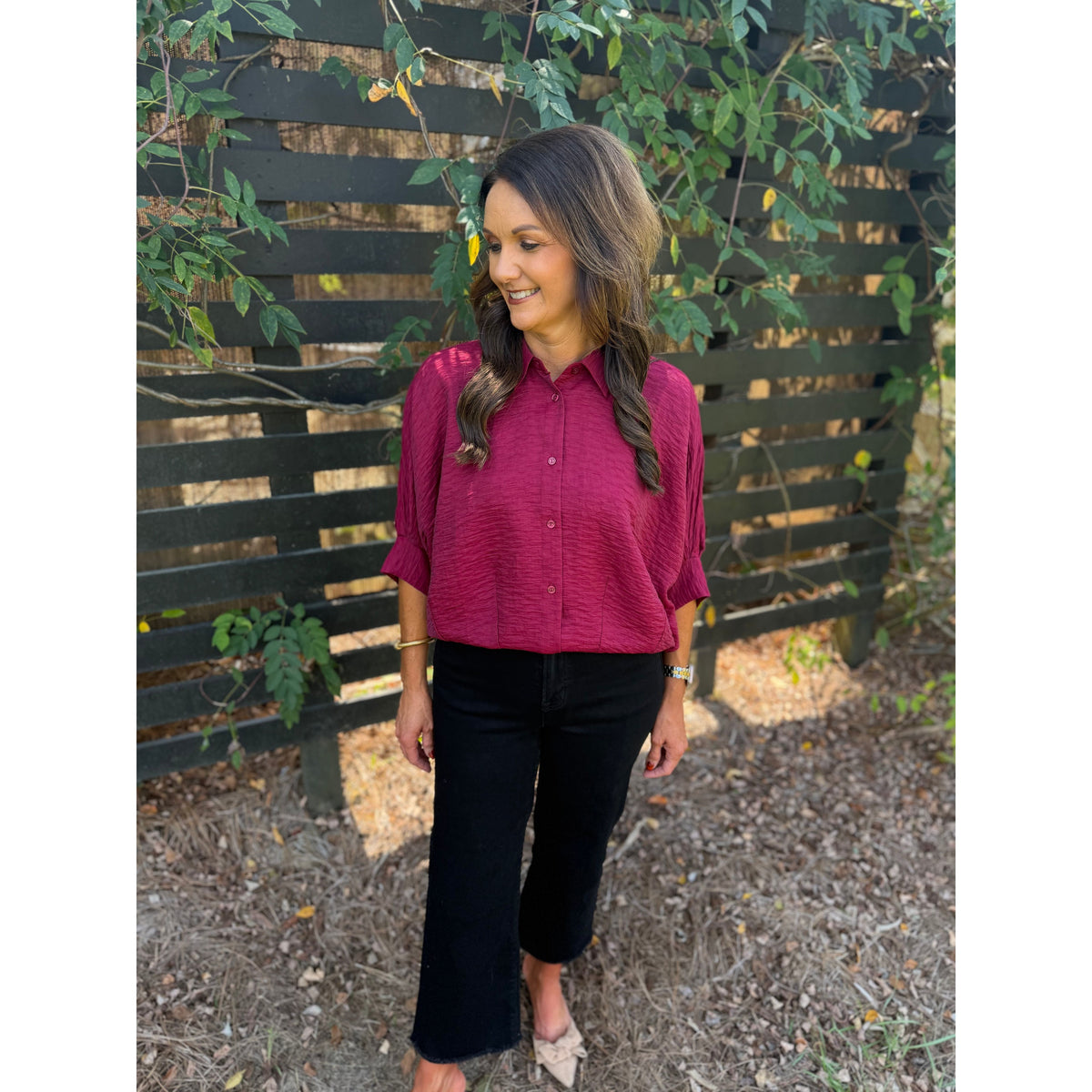Annie Ks Boutique burgundy textured short sleeve blouse with a button-front and collar worn with black cropped jeans.