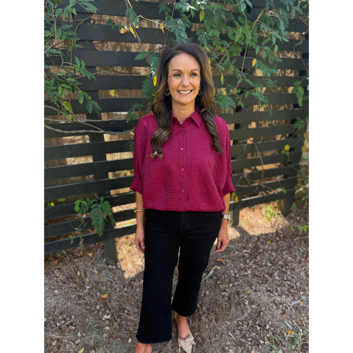 Annie Ks Boutique burgundy textured short sleeve blouse with a button-front and collar worn by a smiling woman