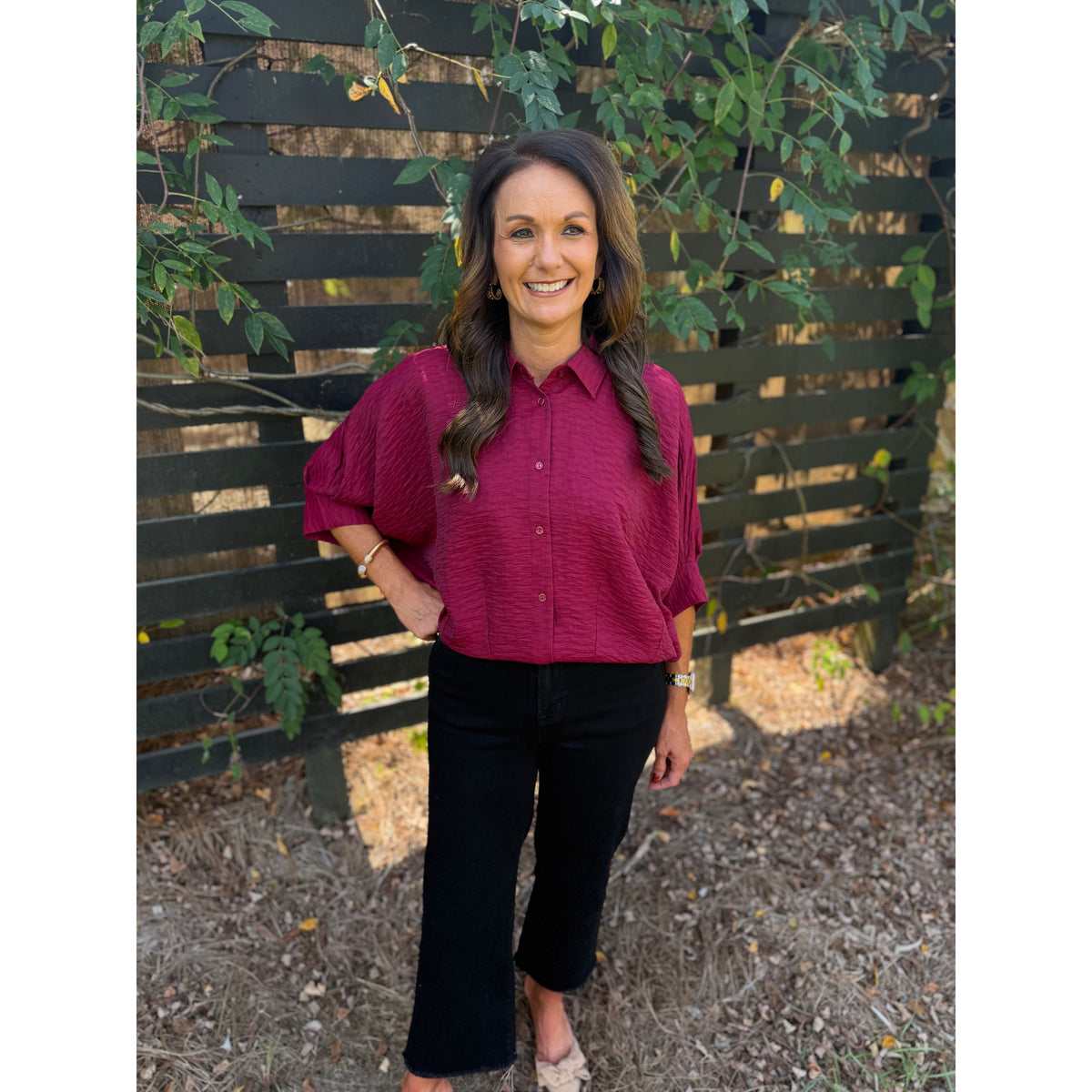 Annie Ks Boutique burgundy textured short sleeve blouse with a collar and button-front worn with black trousers
