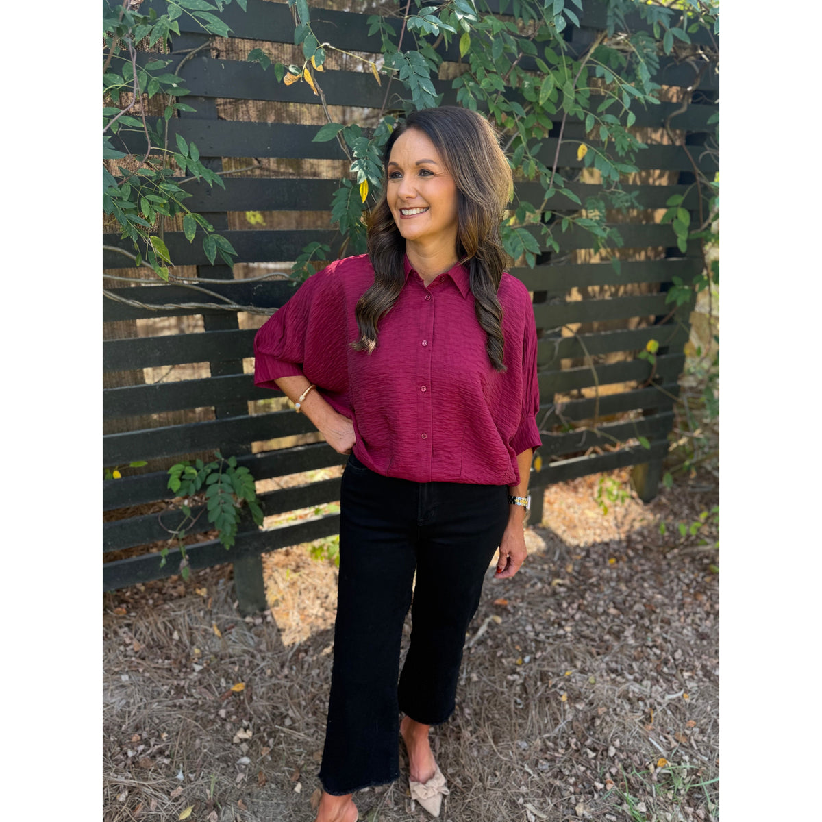 Annie Ks Boutique burgundy textured short sleeve blouse with a collar and button-front worn with black cropped jeans.