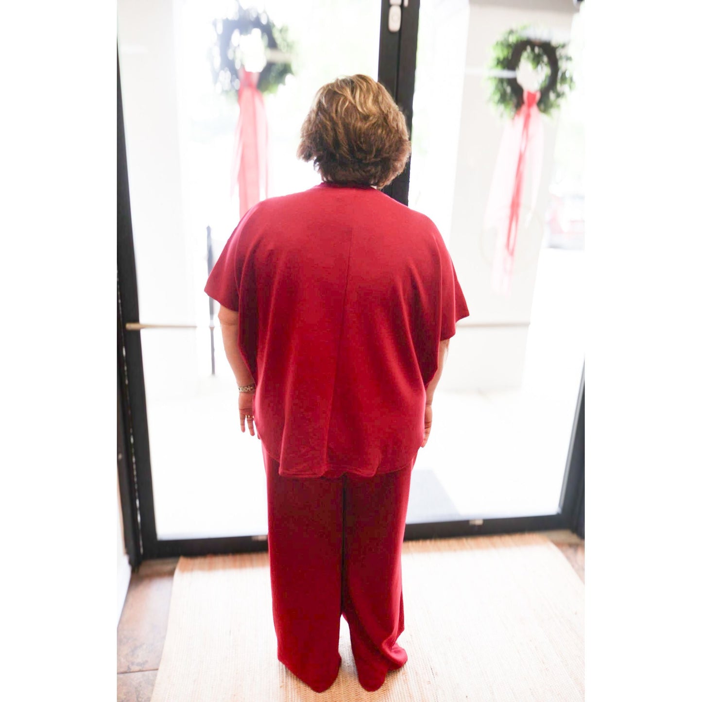 Back view of a woman wearing an Annie Ks Boutique cabernet scuba knit pullover top and matching wide-leg pants set.