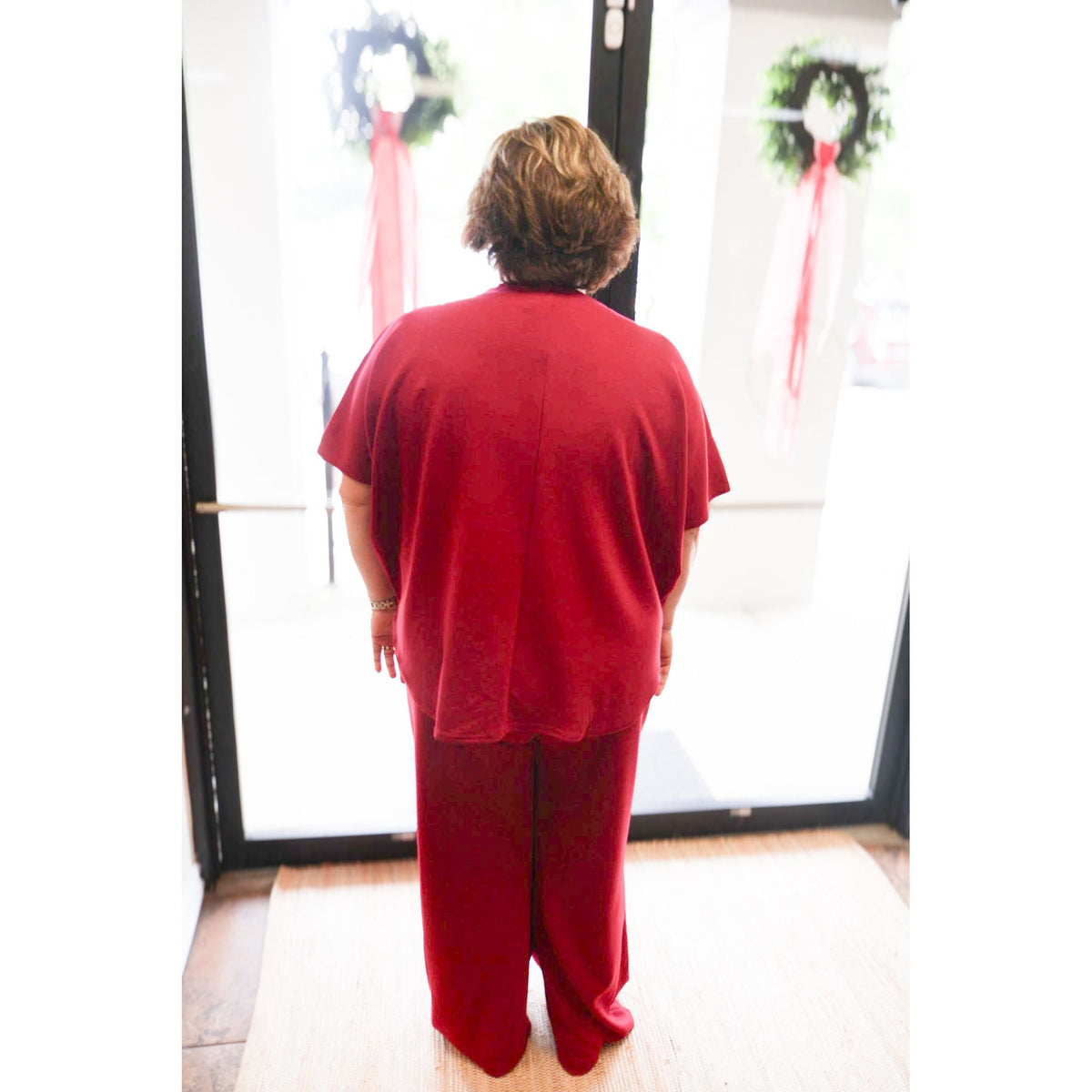 Back view of a woman wearing an Annie Ks Boutique cabernet scuba knit pullover top and matching wide-leg pants set.