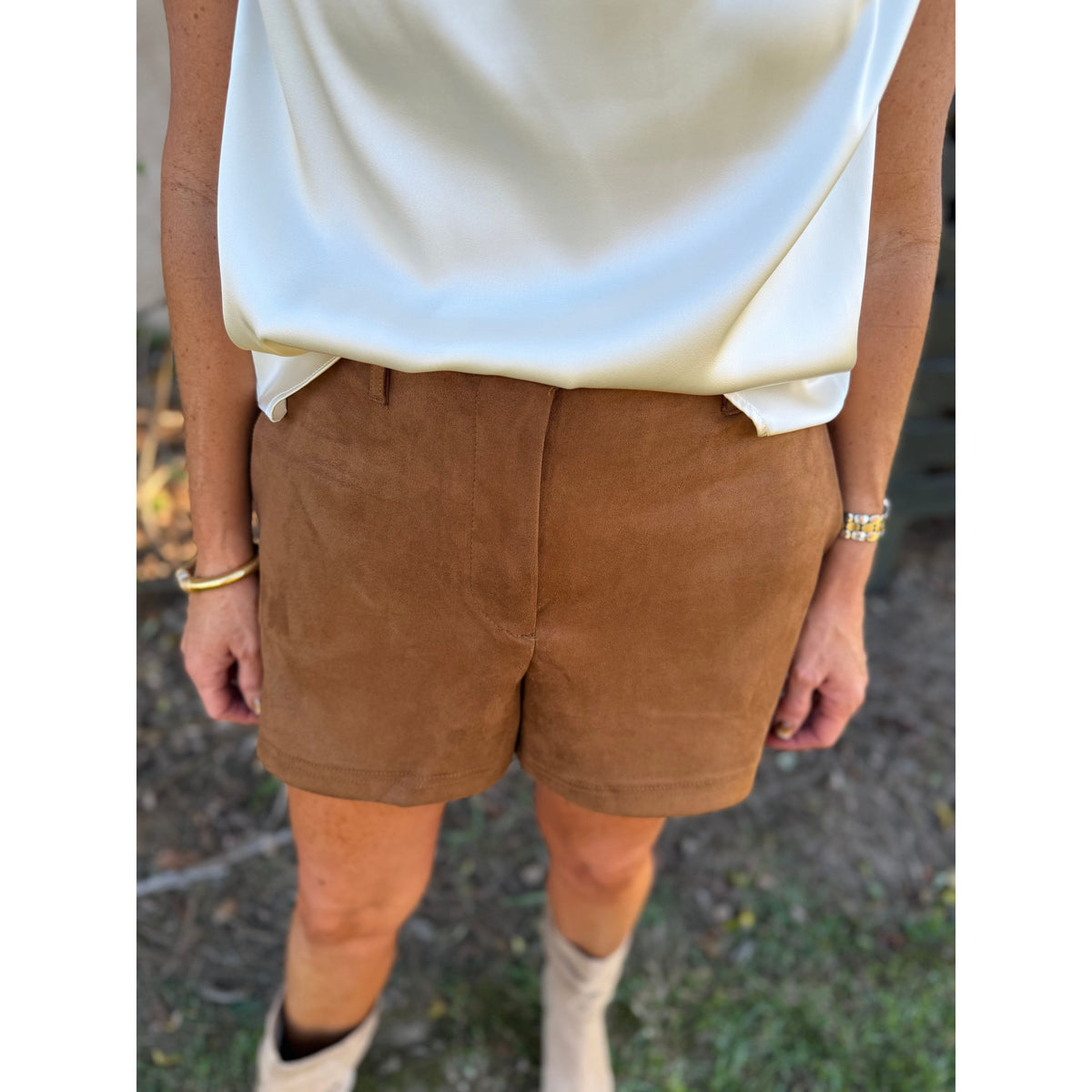 Annie Ks Boutique camel brown faux suede shorts paired with a cream satin top and ankle boots