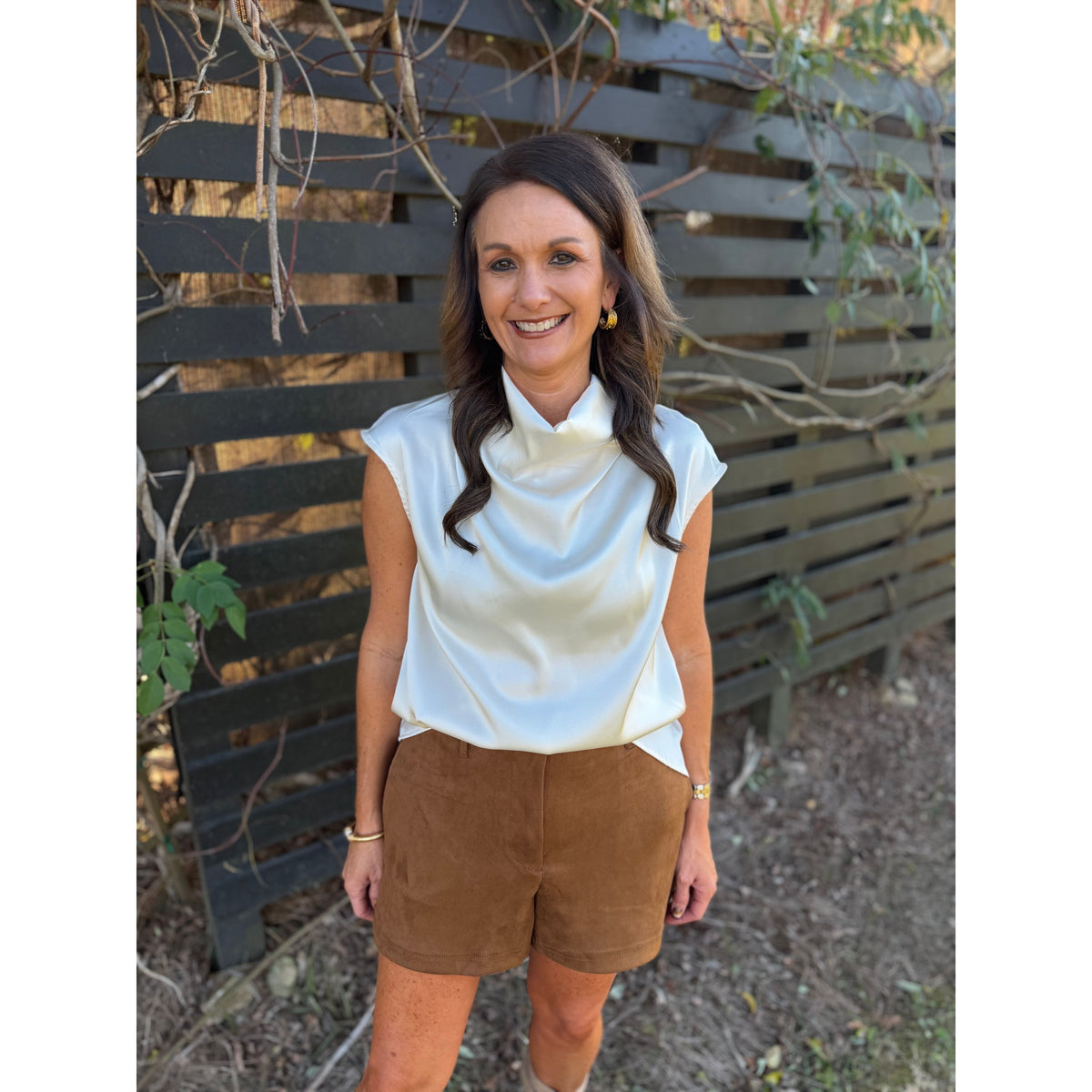 Annie Ks Boutique camel brown faux suede shorts with a relaxed fit and side pockets worn by a smiling woman