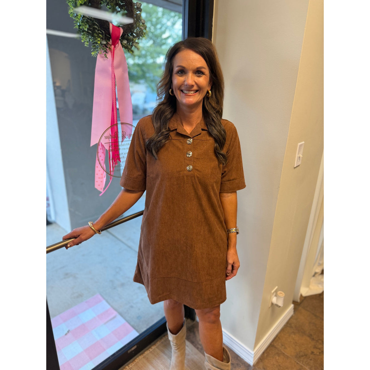 Annie Ks Boutique caramel corduroy mini dress with gold buttons and collared neckline worn by a smiling woman