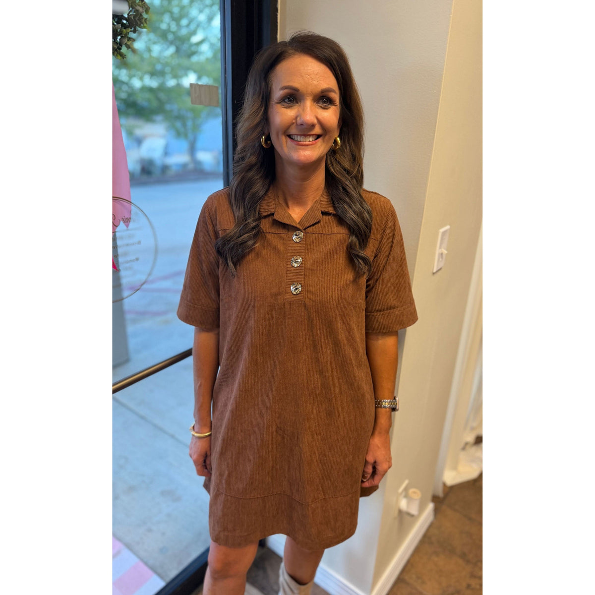 Woman wearing an Annie Ks Boutique caramel corduroy mini dress with gold buttons and a collared neckline