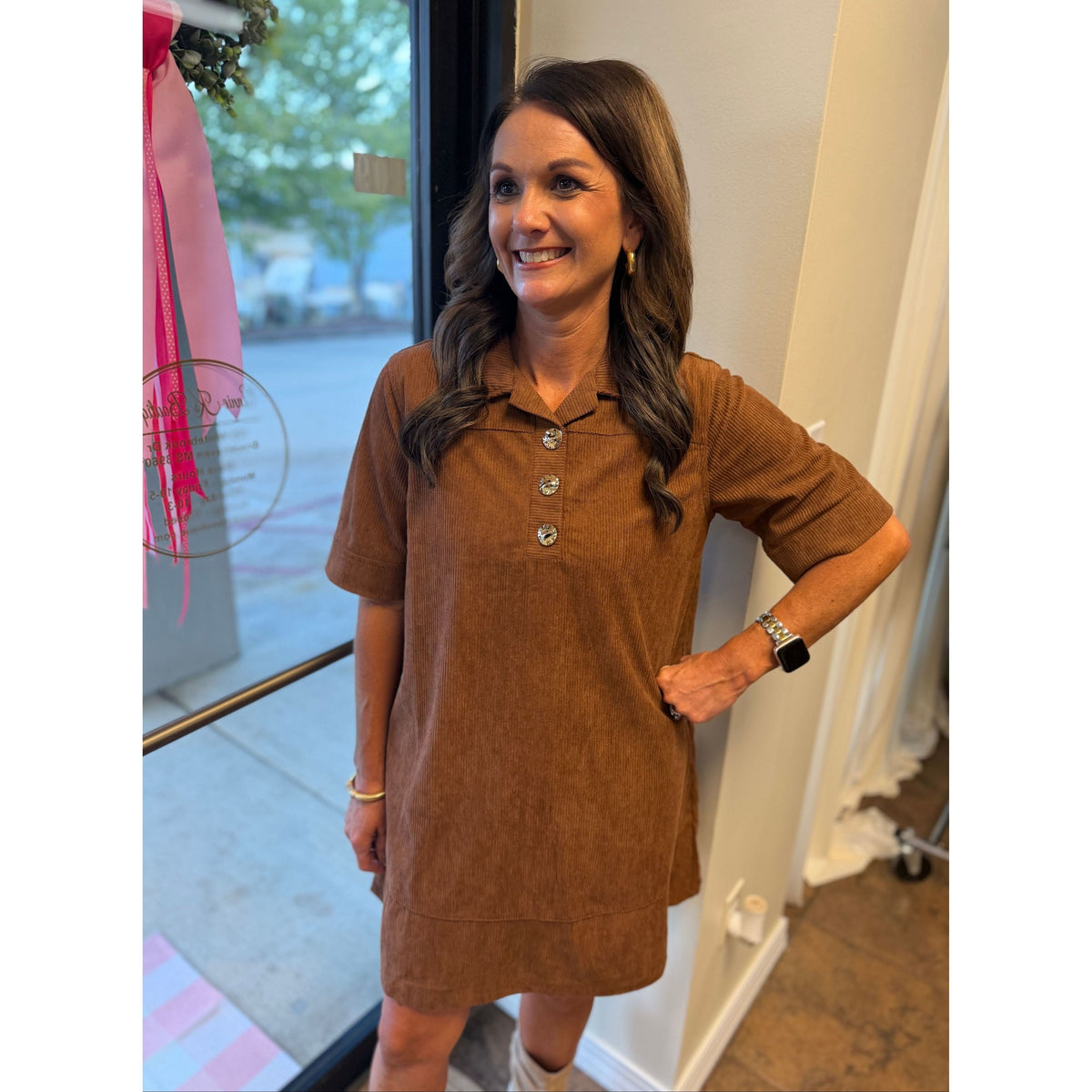 Annie Ks Boutique caramel corduroy mini dress with a collared neckline and gold button details worn by a smiling woman