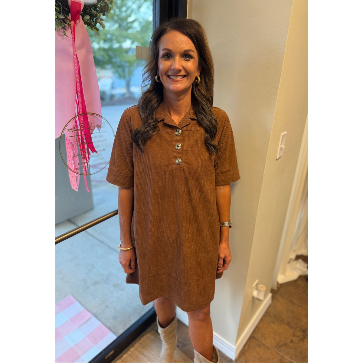 Annie Ks Boutique caramel corduroy mini dress with gold buttons and collared neckline worn by a smiling woman