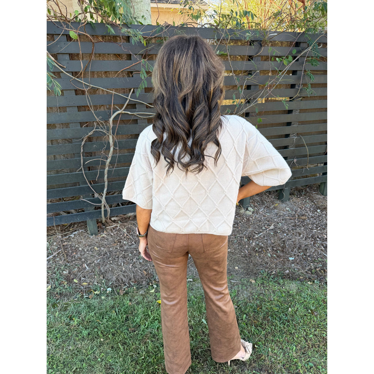 Annie Ks Boutique caramel faux suede bootcut cropped pants worn with a cream quilted sweater, back view